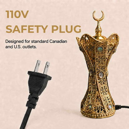 An ornate gold-toned decorative lamp with a crescent moon finial and filigree detailing, shown beside a black two-prong safety plug on a light beige background. Text reads '110V SAFETY PLUG' and 'Designed for standard Canadian and U.