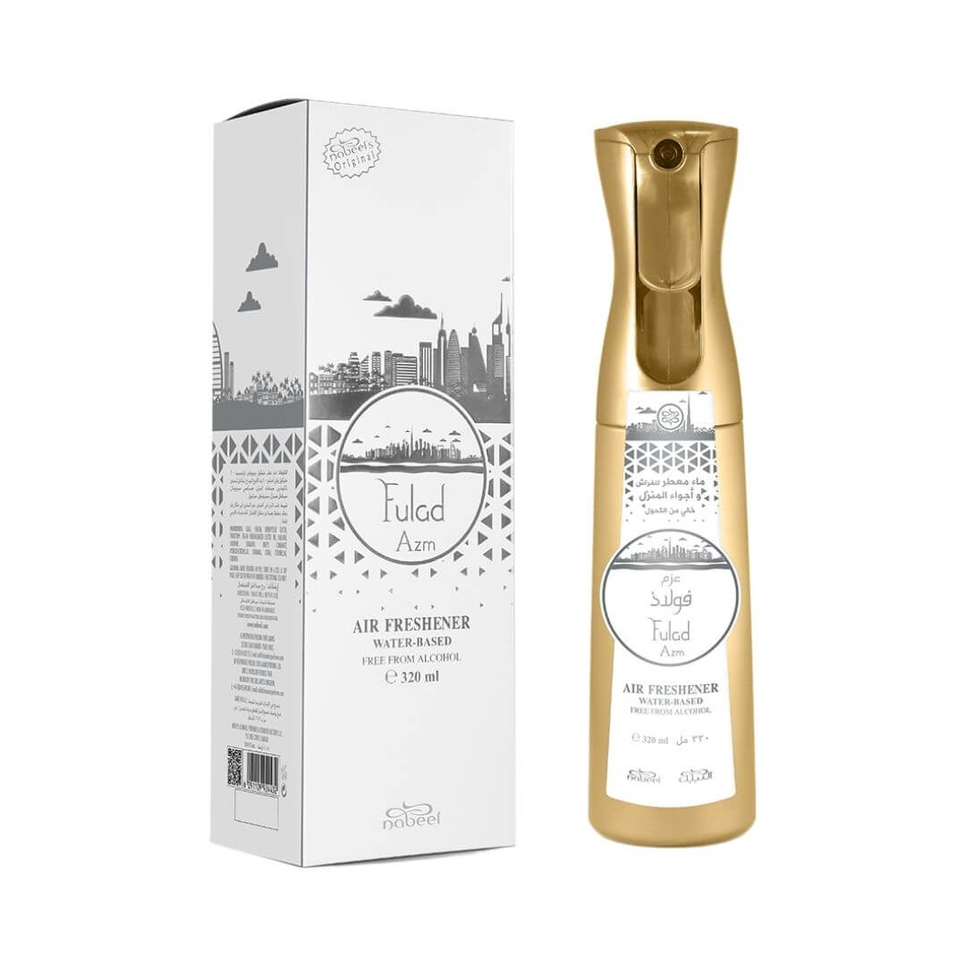 On the left, a box with Nabeel and Fulad Azm branding. On the right, a gold air freshener bottle with white sticker that has Nabeel and Fulad Azm branding on a white background.