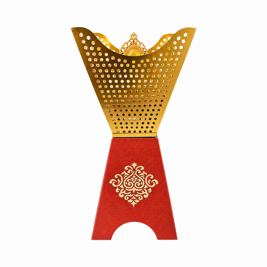 A decorative metal bakhoor burner with a gold top and a red base featuring an ornate gold pattern, shown against a plain white background.